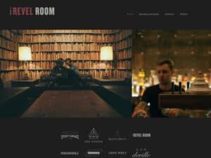 Revel Room website. A screenshot of a website for a chic lounge and nightclub. The dark maroon and grey logo in the upper left says "The Revel Room" in a stark, blocky font. Some links in a small grey font are on the right. Below that are images of a dimly-lit room with a wall of bookshelves full of books, two low-light lamps and a couple sitting at a couch clinking glasses. To the right is a bartender with short hair and tattoos seen standing at beer tap with a soft-focus bar with bottles visible behind him.